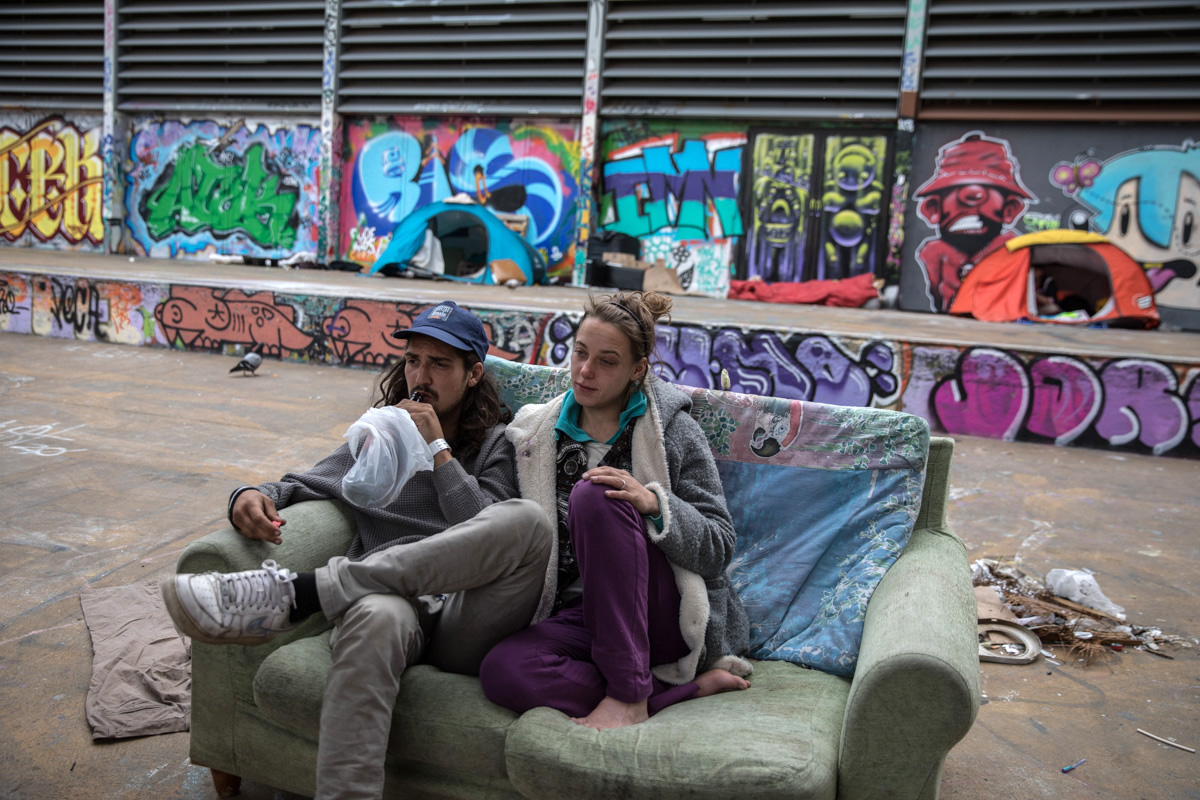 A couple from Sweden who has been living on the streets of Barcelona for 6 months, has settled during confinement in a square of the city center with a tent. They would like to be able to confine themselves to a shelter for homeless people, but they would be forced to be separated, he in a men's shelter and she in a women's one. So they prefer to sleep on the street together. Barcelona, March 27th. Photo by Eva Parey.